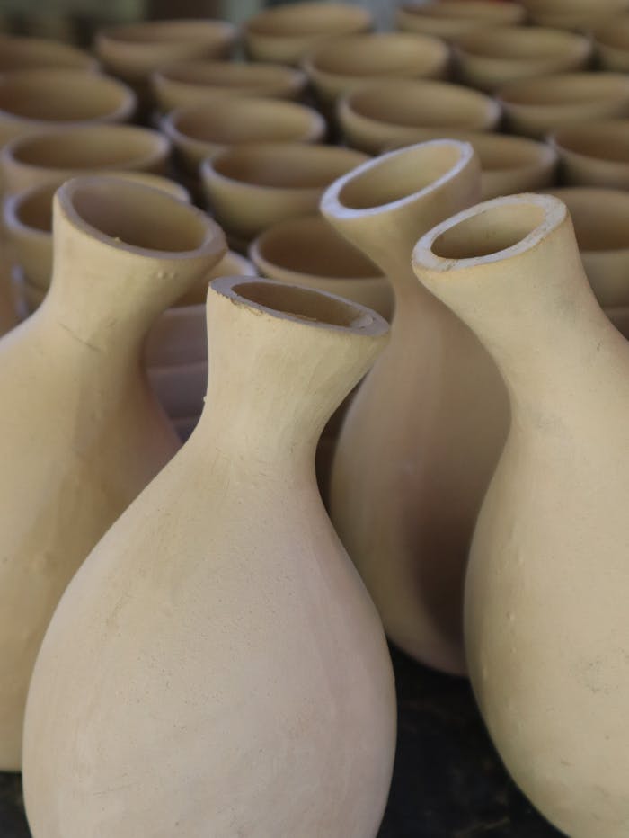 Services-03 Close-up of artisanal handmade ceramic vases in a pottery workshop.